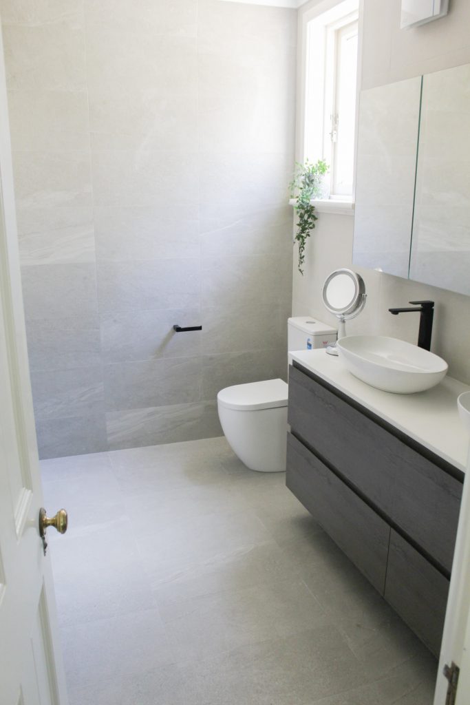 after-bathroom-renovation-double-vanity-black-fixtures-natural-light-white-countertop