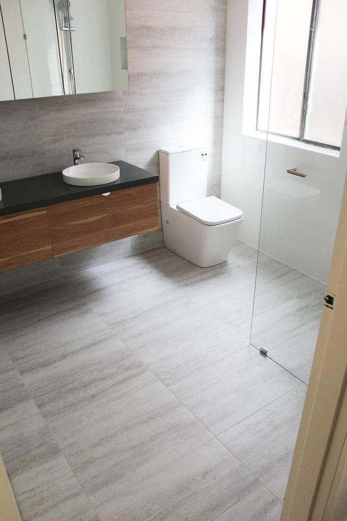 after-bathroom-renovation-modern-tiles-black-countertop-double-vanity