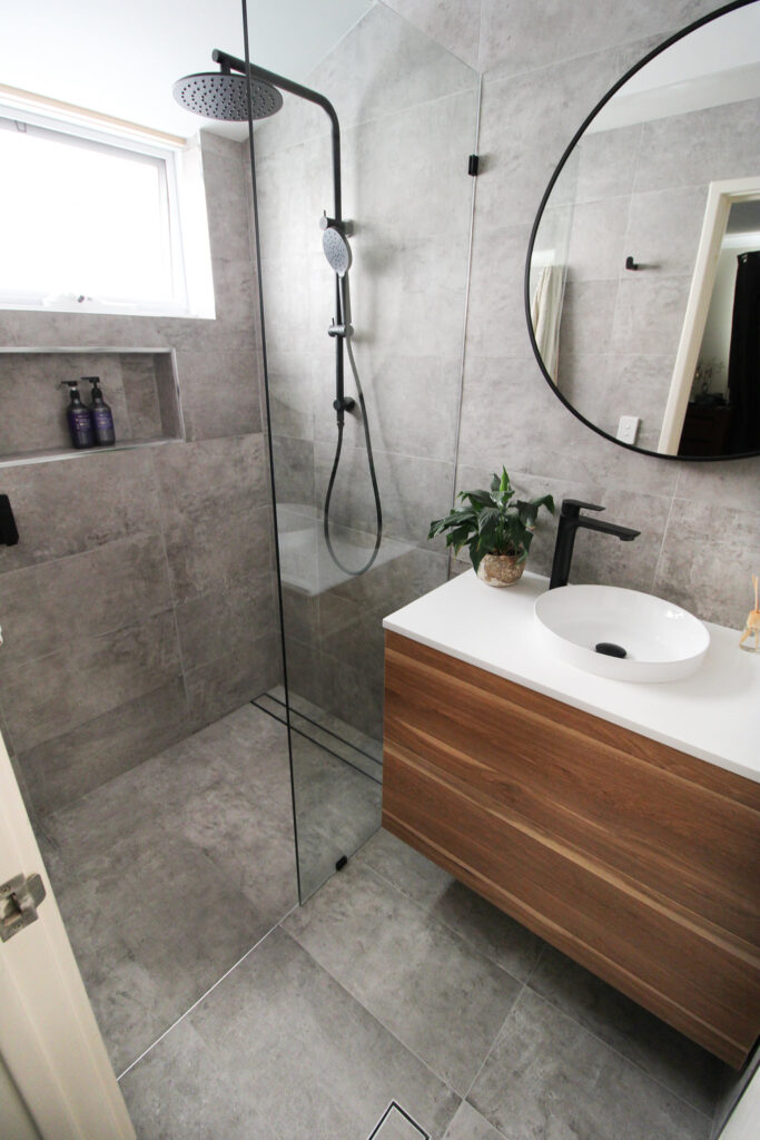after-bathroom-renovation-grey-tiles-glass-door-shower-niche-floating-vanity-rounded-mirror