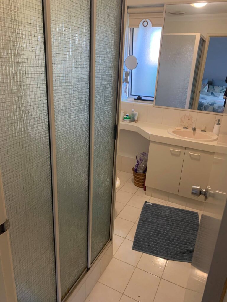before-bathroom-renovation-outdated-white-tiles-long-mirror-single-vanity